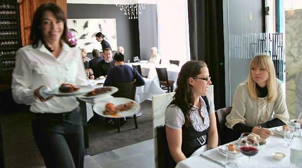 Server carrying beautiful meals to table.