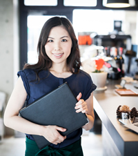 Restaurant owner with menu covers in her hands.